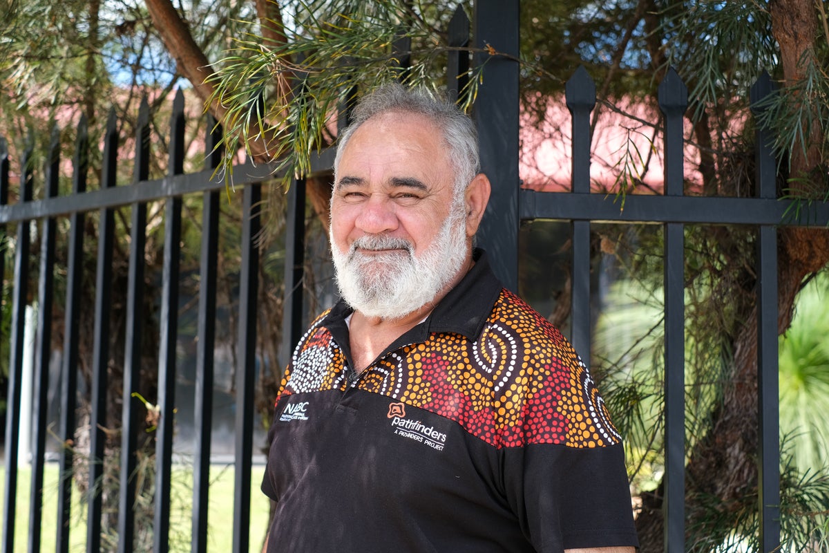 A man standing in front of a gate.