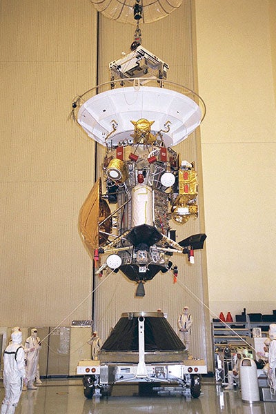 The Cassini-Huygens spacecraft being loaded onto its launch vehicle adapter at Jet Propulsion Lab, July 22, 1997; Huygens is the bronze saucer shape at bottom left of Cassini  (Wikimedia commons)