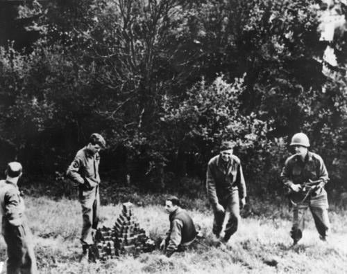 Alsos personnel uncovering buried uranium bricks at Haigerloch, with Goudsmit in the hole at center, photograph, 1945, Emilio Segrè Visual Archives, AIP (repository.aip.org)