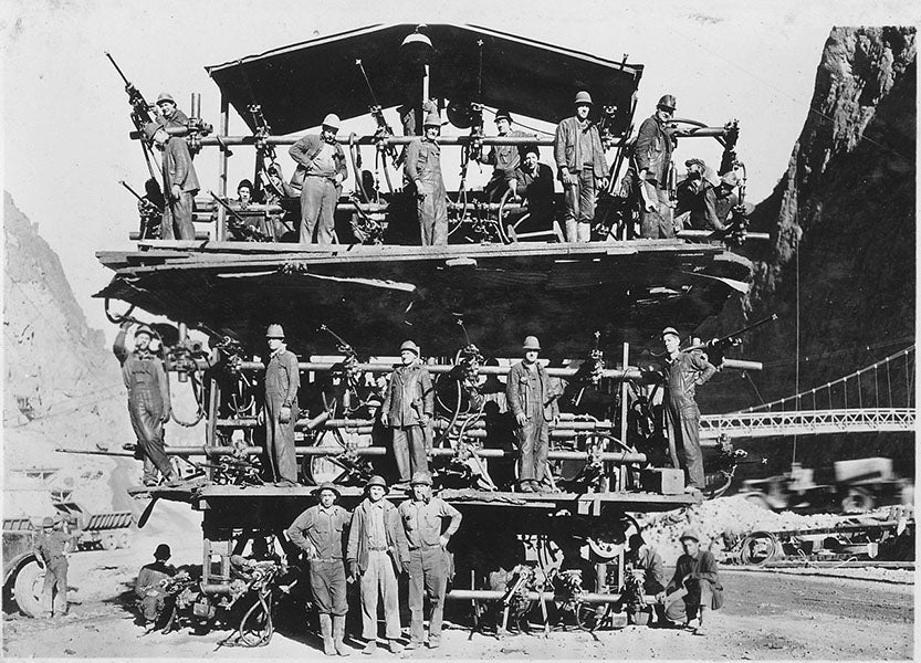“Jumbo” drilling rig, devised by Frank Crowe, which could drill 30 holes for dynamite simultaneously, used for digging the diversion tunnels, photograph, 1931 (Wikimedia commons)