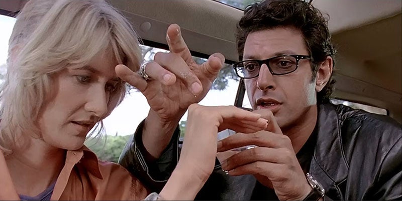 Ian Malcolm (Jeff Goldblum) demonstrating chaos theory to Dr. Ellie Sattler (Laura Dern), still photo from Jurassic Park, 1993 (cbr.com)