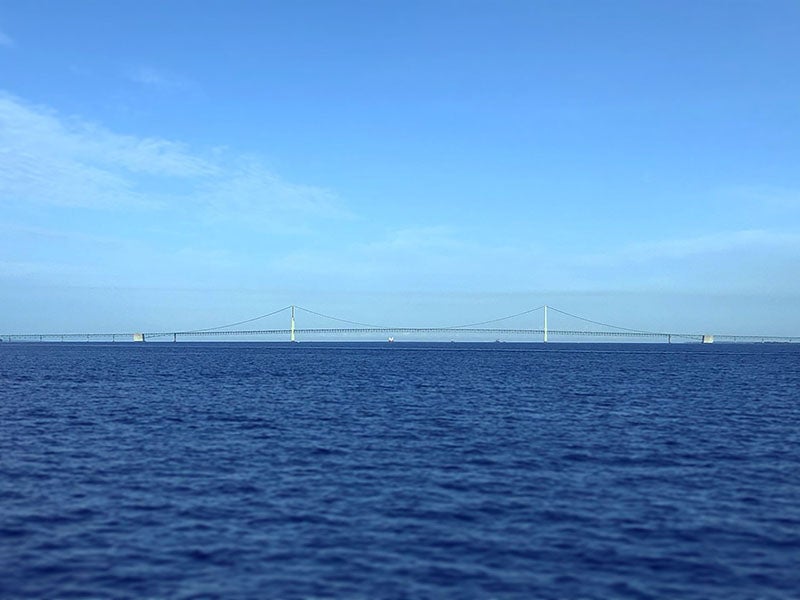 Long view of the Mackinac Bridge, showing that the “hump” often seen in photographs is a telephoto foreshortening illusion (Wikimedia commons)