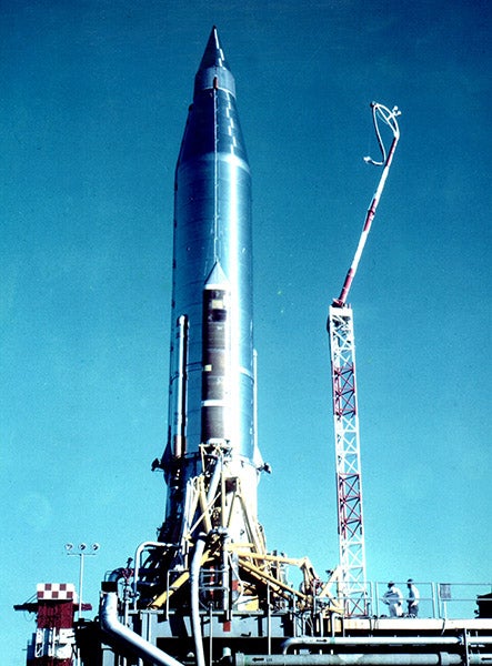 Atlas 10B rocket on the launch pad at Cape Canaveral, with the SCORE tape recorders and radios under the fairings at top, photograph, December 1958 (Wikimedia commons)