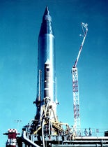 Atlas 10B rocket on the launch pad at Cape Canaveral, with the SCORE tape recorders and radios under the fairings at top, photograph, December 1958 (Wikimedia commons)
