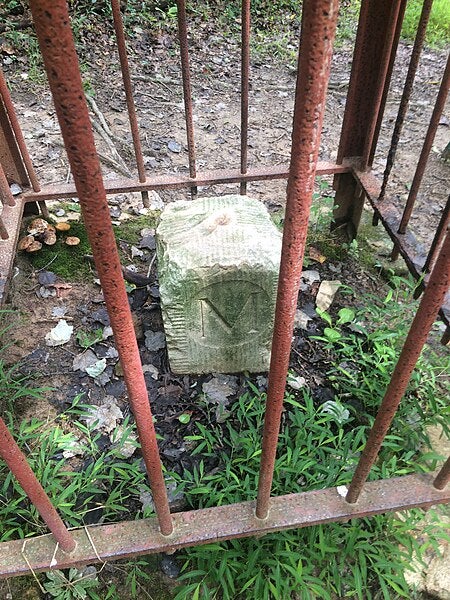 Milestone no. 19 on the Mason-Dixon line between Pennsylvania and Maryland; this is the Maryland side, denoted by the “M,” and is protected by an iron cage (Wikimedia commons)