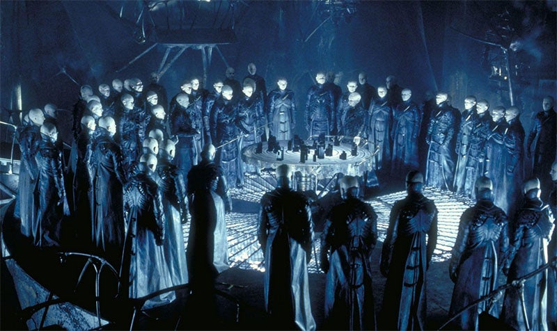 The “Strangers” in the underworld, standing around a model of the City above, a movie still from Dark City (1998), Internet Movie Database (imdb.com)