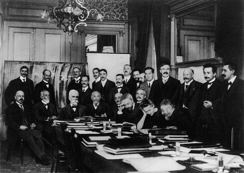 First Solvay Conference, 1911, group photograph, with Hendrik Antoon Lorentz in the center at the far end of the table, next to the pasted-on head of the founder and sponsor, Ernest Solvay, who missed the photo session (Wikimedia commons)