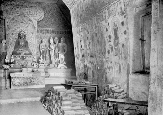 Cave 16 at Mogao, with scrolls from the next-door Cave 17 stacked on the floor, photograph by Aurel Stein, 1907 (Wikimedia commons)