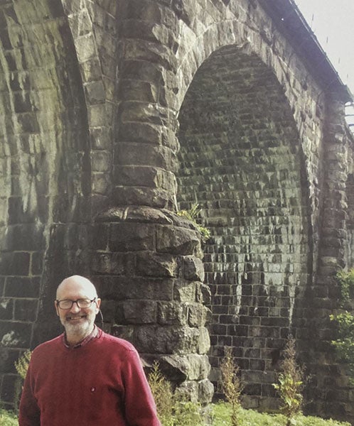 Photograph of Eric DeLony standing by the Thomas Viaduct, built in 1835 in Elkridge, Maryland, in a book dedicated to DeLony, Covered Bridges and the Birth of American Engineering, ed. by Justine Christianson and Christopher Marston, HAER, 2015; photo by Christopher Marston, 2012 (Linda Hall Library)