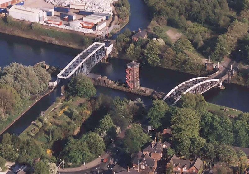 Aerial view of Barton Swing Aqueduct on the left, with the Bridgewater Canal, running top to bottom, crossing the Manchester Ship Canal, modern photograph (Wikimedia commons)