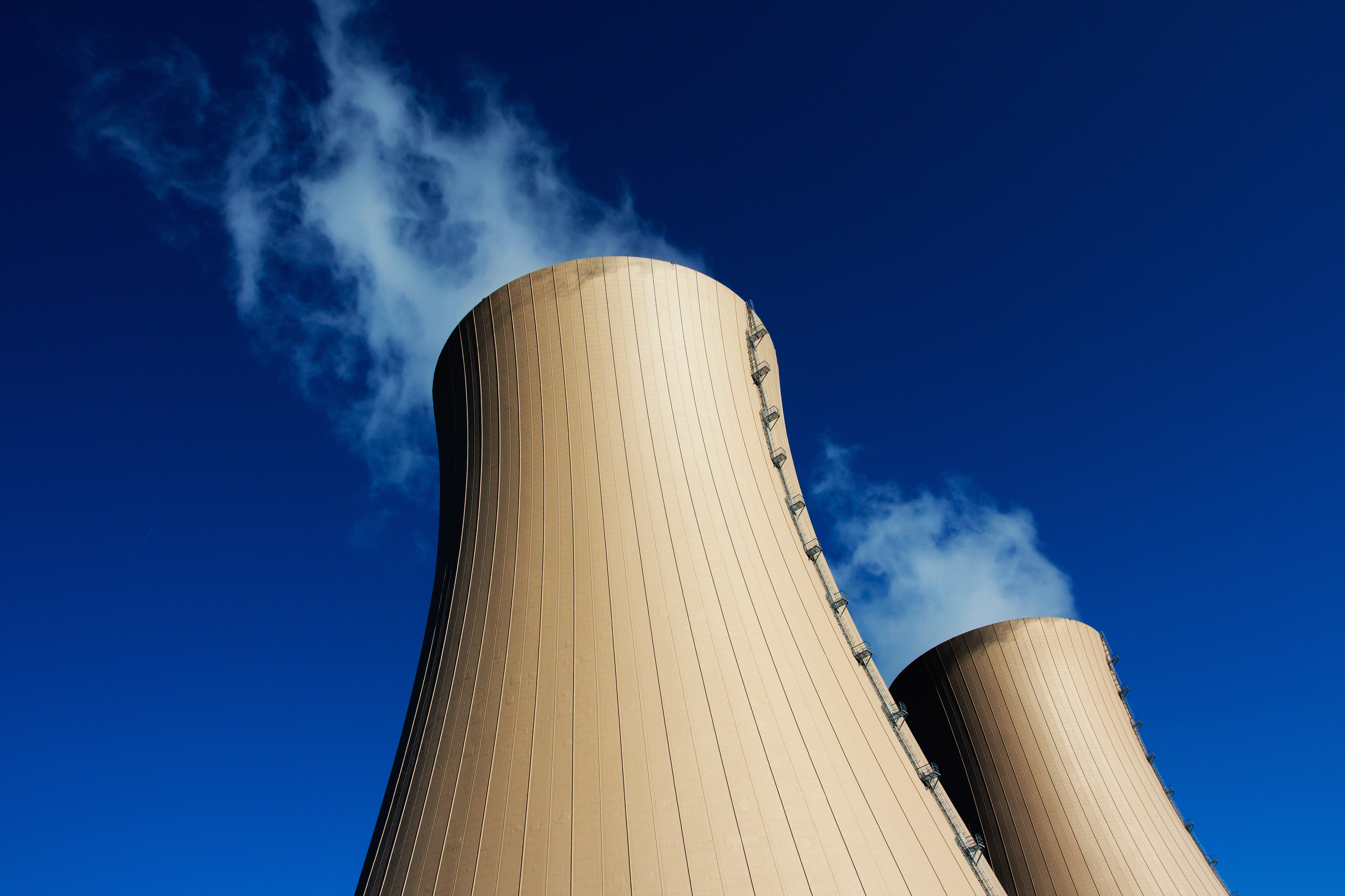 Image of cooling towers of nuclear power plant against blue sky