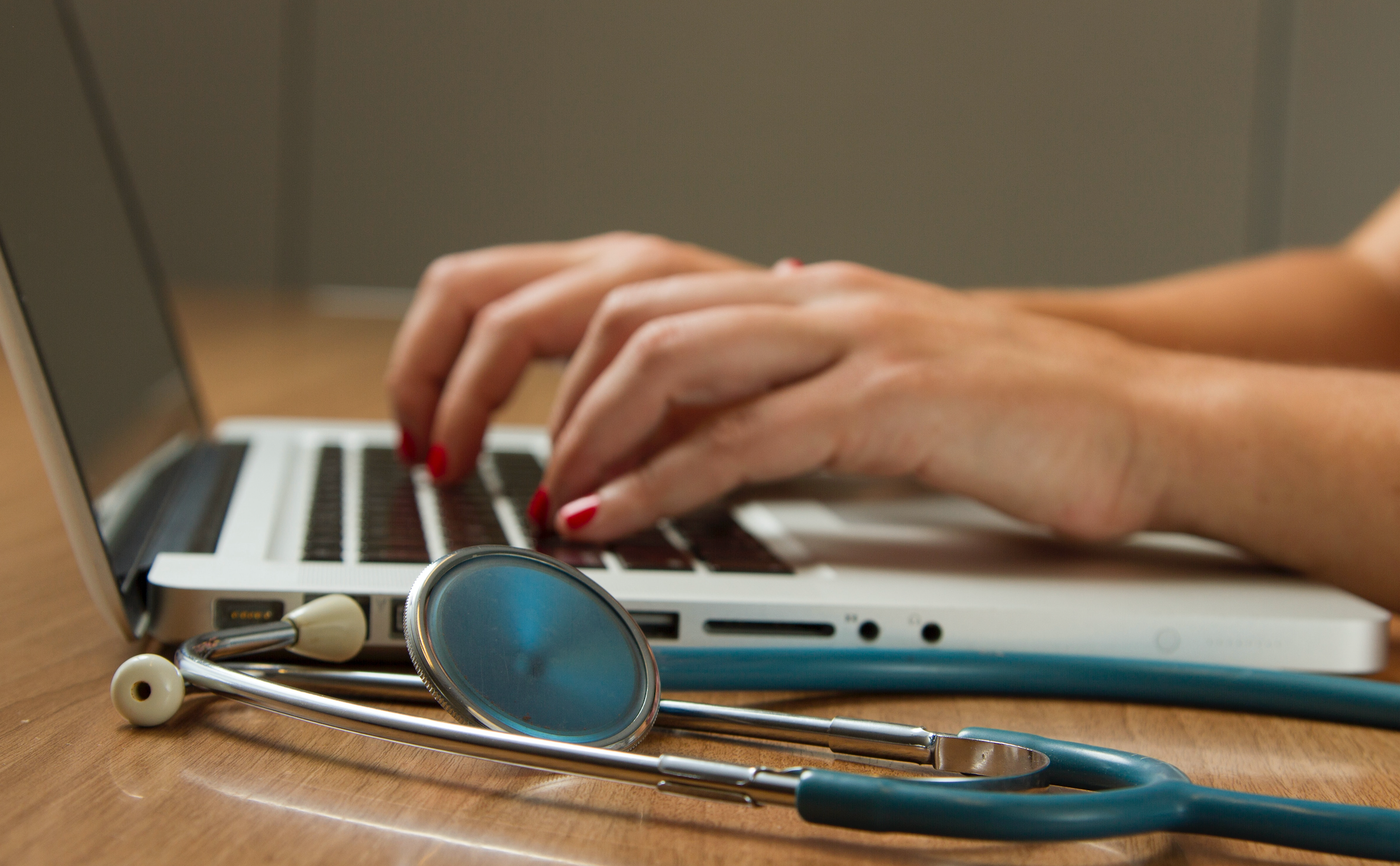 Hands typing on laptop
