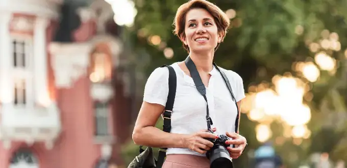Turista explorando una ciudad con cámara fotográfica, ideal para representar experiencias de viaje y turismo urbano.