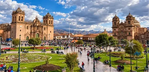 Plaza de Armas de Cusco con arquitectura colonial, iglesias históricas y montañas andinas al fondo, Perú.