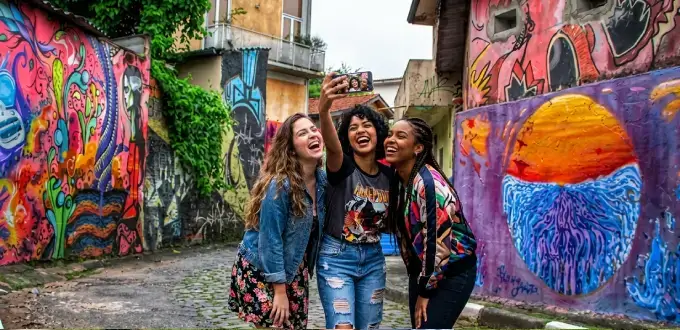 Amigas tomándose una selfie entre los coloridos murales de Vila Madalena, barrio bohemio de São Paulo, Brasil.