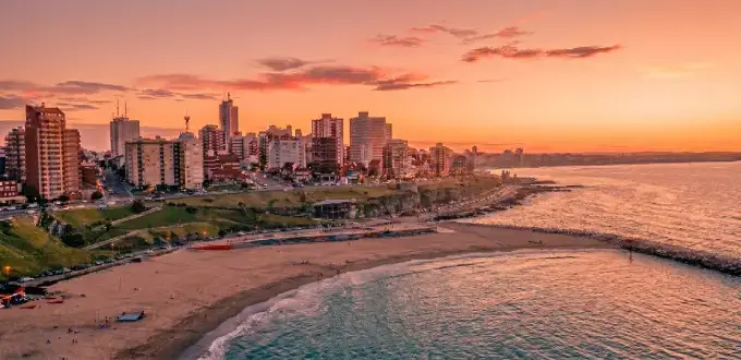 Playa Grande en Mar del Plata, Argentina, al atardecer, con costa, mar y skyline urbano frente al Atlántico.
