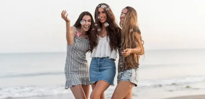 Amigas disfrutando la playa en Florianópolis, Brasil, con el mar de fondo y un ambiente de vacaciones.