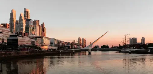 Puerto Madero en Buenos Aires, con Puente de la Mujer, skyline y río al atardecer.