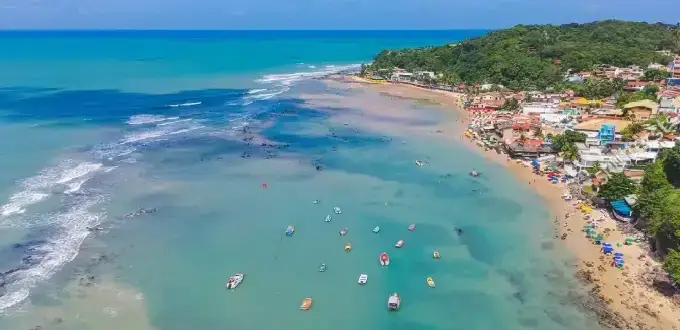 Playa de Pipa en Brasil con aguas turquesas, botes y costa rodeada de vegetación en Rio Grande do Norte.