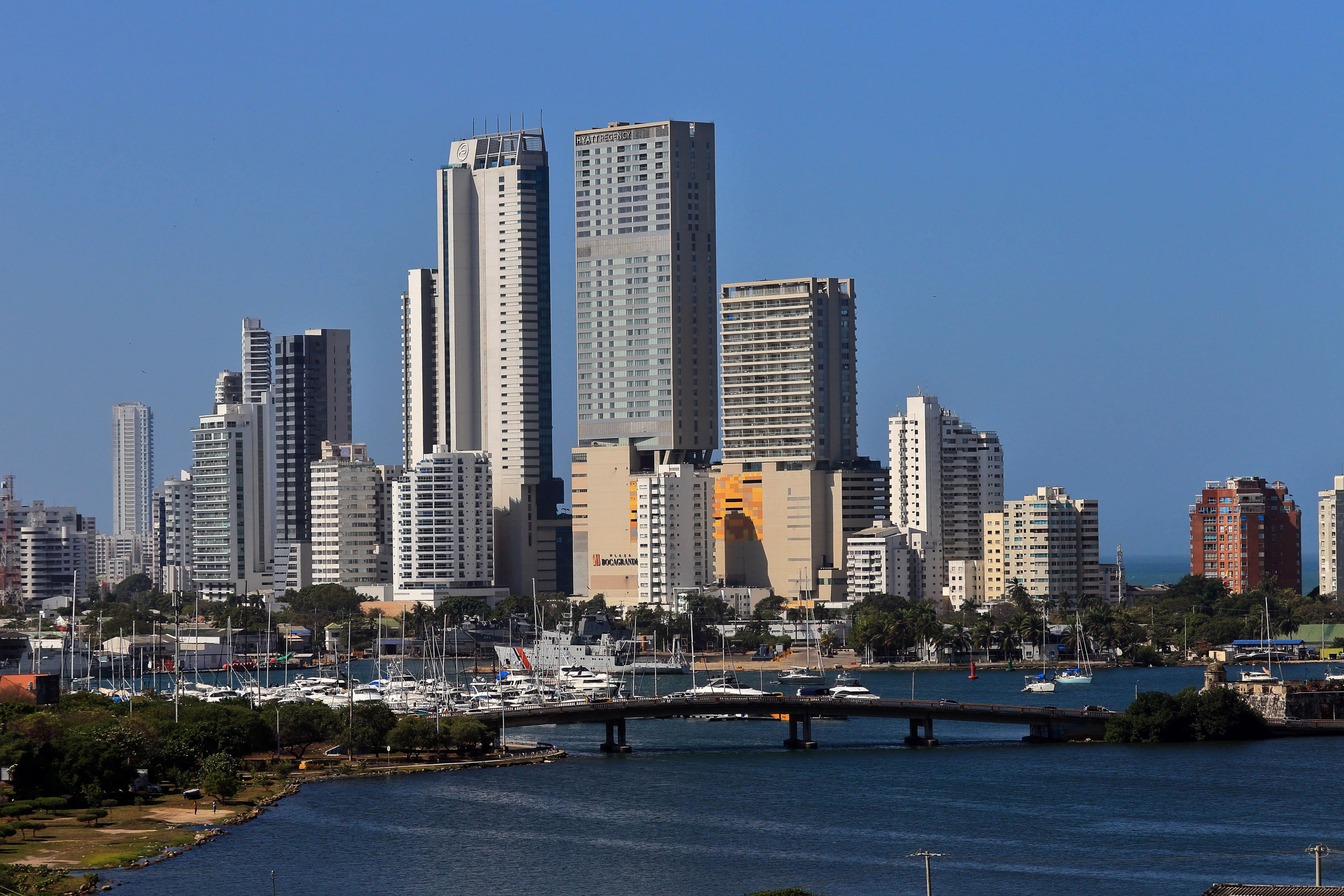 Vista de los rascacielos de Cartagena moderna frente a la bahía, con muelle y embarcaciones en primer plano.