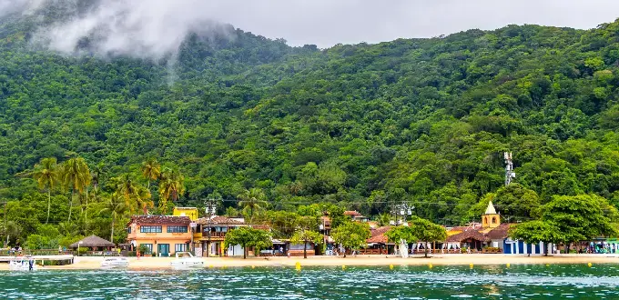 Ilha Grande, Brasil, con costa tropical, aguas cristalinas, vegetación exuberante y montañas frente al mar.
