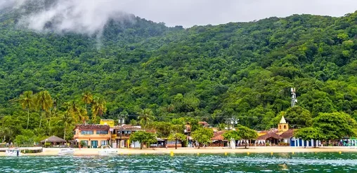 Ilha Grande, Brasil, con costa tropical, aguas cristalinas, vegetación exuberante y montañas frente al mar.
