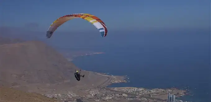Parapente sobre Iquique, Chile: vuelo frente al océano Pacífico con vista aérea de la ciudad y el desierto costero.