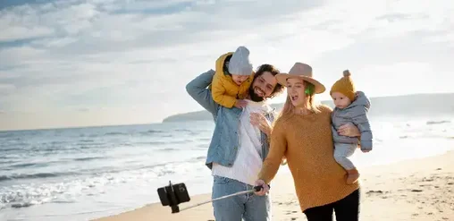 Familia disfrutando la playa de La Serena, tomándose una selfie frente al mar en un día soleado.