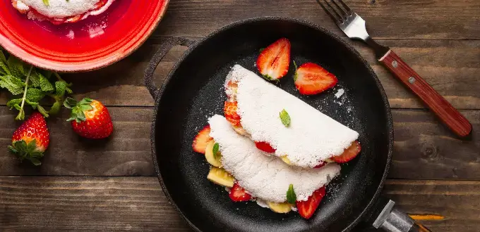 Tapioca brasileña con fresas, un plato típico de la gastronomía de Brasil sobre una mesa rústica.