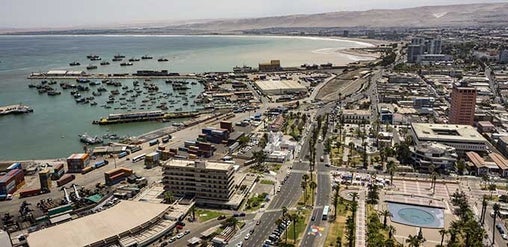Vista aérea del puerto de Arica, con barcos pesqueros, contenedores, ciudad costera y el océano Pacífico, Arica, Chile.