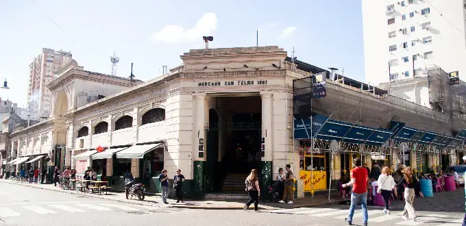Mercado de San Telmo en Buenos Aires, con puestos, cafés y visitantes.