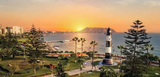 Atardecer en el Parque del Amor de Miraflores, Lima, con vista al océano Pacífico y la costa peruana.