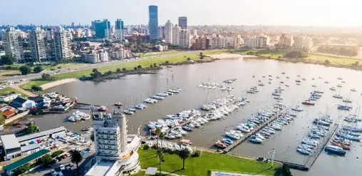 Puerto del Buceo en Montevideo, Uruguay, con marina, embarcaciones y edificios de la ciudad junto a la costa.