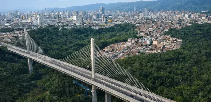 Puente atirantado sobre zona verde con vista panorámica de Bucaramanga, Colombia.