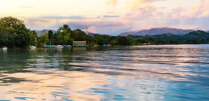 Laguna Sauce, Tarapoto, Perú, con aguas tranquilas, vegetación amazónica y montañas al fondo.