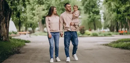 Familia camina por un parque arbolado en Ñuñoa, Santiago, disfrutando un paseo tranquilo al aire libre.