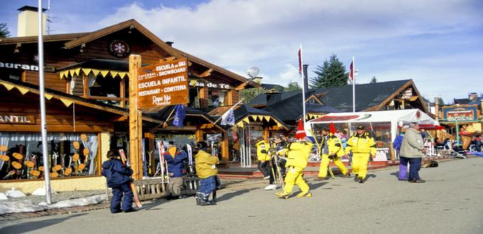 Niños y esquiadores frente a una escuela de ski en Bariloche, Argentina.