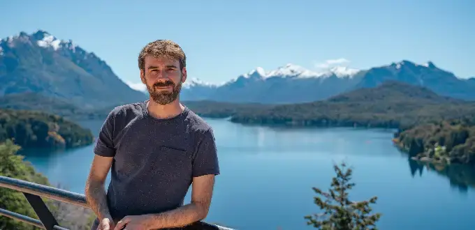 Persona frente al lago Lácar con montañas nevadas en San Martín de los Andes, Argentina.