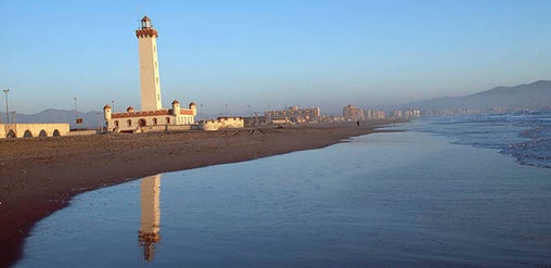 Faro Monumental junto a la Playa El Faro, con costa tranquila y reflejos al atardecer en La Serena, Chile.
