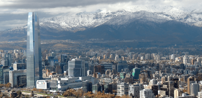 Vista urbana de Santiago de Chile con el Costanera Center y la Cordillera de los Andes nevada al fondo.