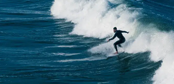 Surfista montando una ola en la playa de Reñaca, Viña del Mar, uno de los destinos populares para surf en la costa central de Chile.