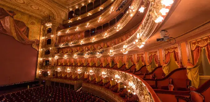 Interior del Teatro Colón en Buenos Aires, con palcos dorados y butacas rojas.