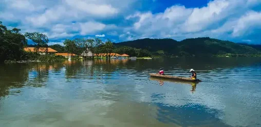 Laguna en Tarapoto, Perú, con paisaje amazónico, montañas verdes y paseo en bote sobre aguas tranquilas.