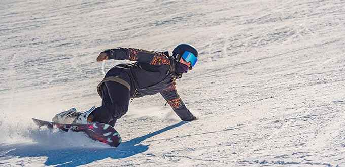 Snowboarder desciende por pista nevada, acción y deporte invernal en centro de ski de la Cordillera de los Andes, Chile.