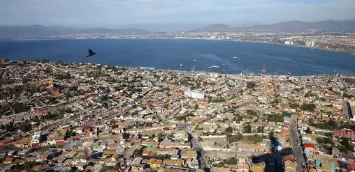 Vista aérea de Coquimbo con barrios urbanos, puerto y bahía azul del Pacífico, Región de Coquimbo, Chile.