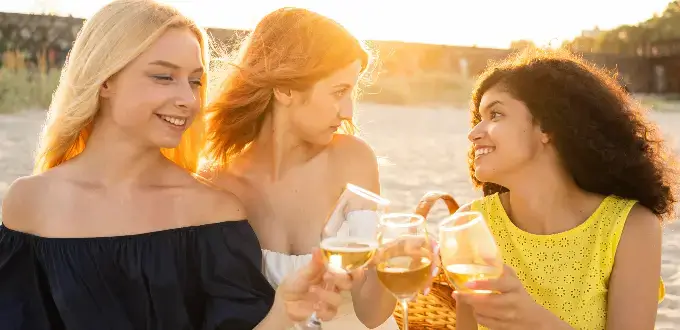 Amigas brindando con vino al atardecer en viñedos de Mendoza, Argentina, turismo enológico.
