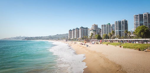 Playa El Sol con arena dorada, mar tranquilo y edificios frente a la costa en Viña del Mar, Chile.