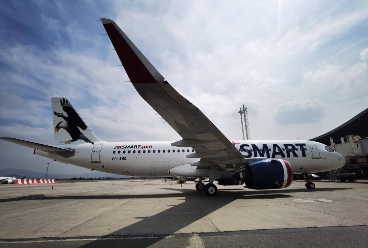 Avión JetSMART modelo Airbus A320 con diseño de ave en la cola, estacionado en el Aeropuerto de Santiago de Chile.
