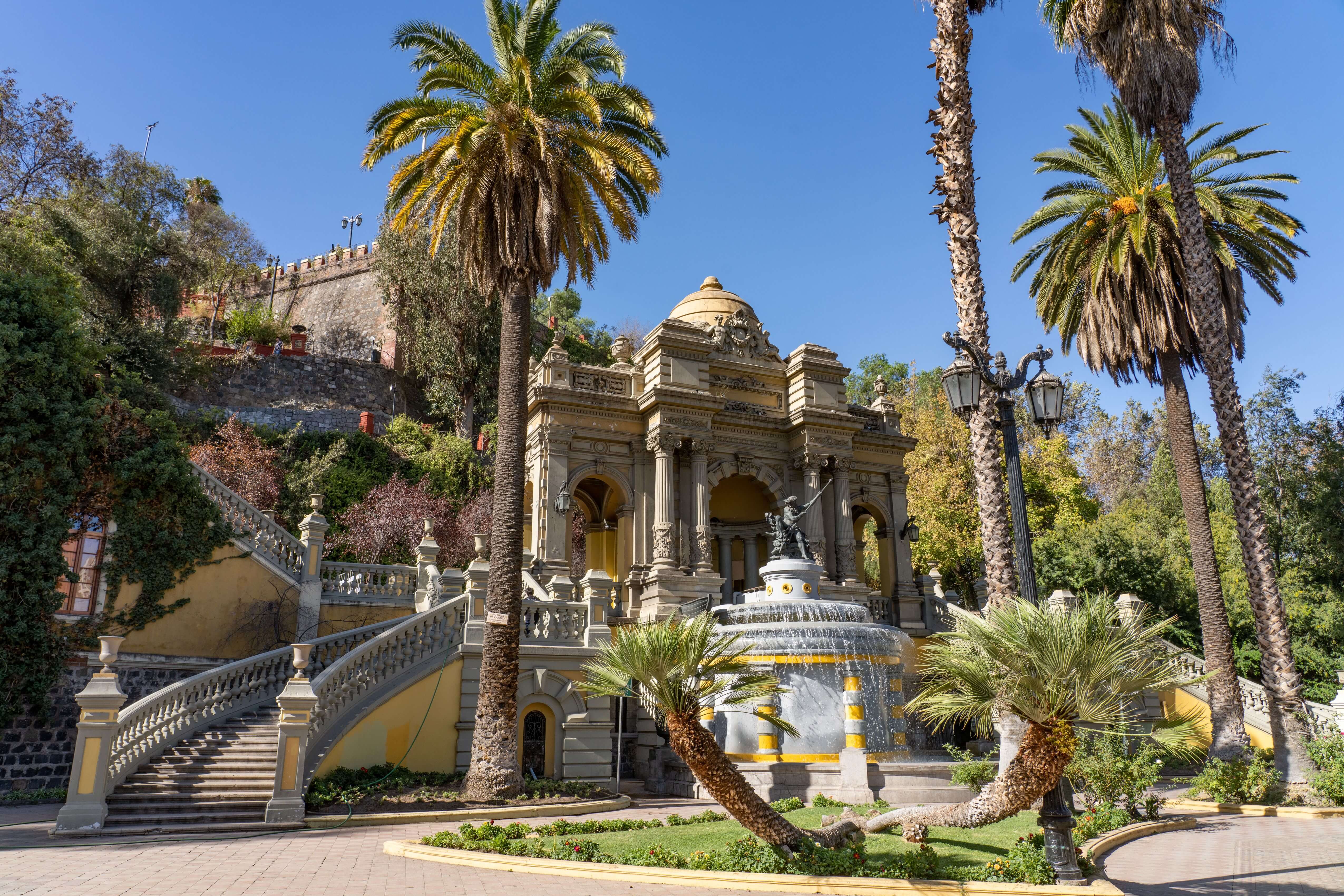 Fuente Neptuno y arquitectura histórica en el Cerro Santa Lucía, rodeado de palmeras y jardines en Santiago de Chile.
