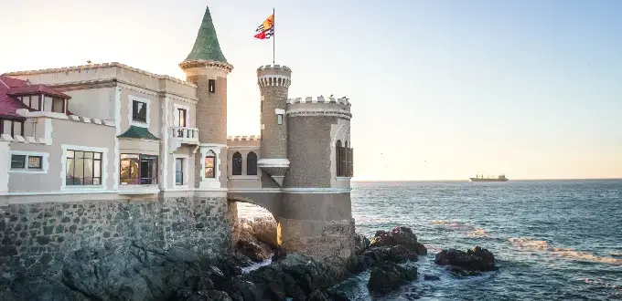 Castillo Wulff sobre rocas frente al océano Pacífico en Viña del Mar, Chile, con torres y arquitectura histórica.

